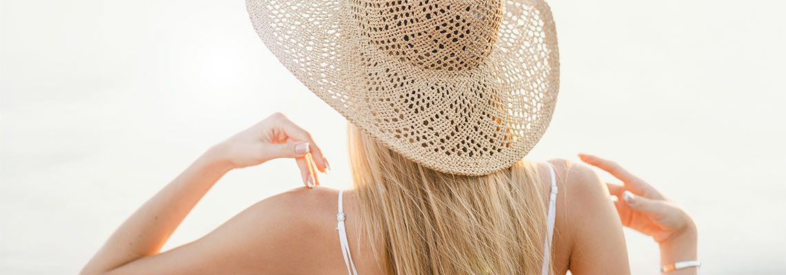 Woman wearing a large straw hat to shade from the hot sun